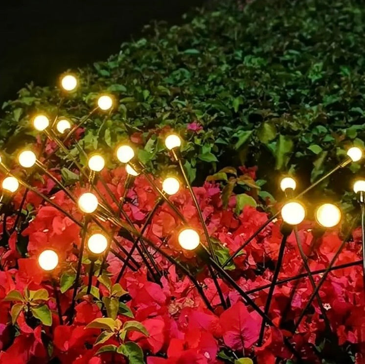 Lampes solaires extérieures LED parmi des plantes rouges en floraison
