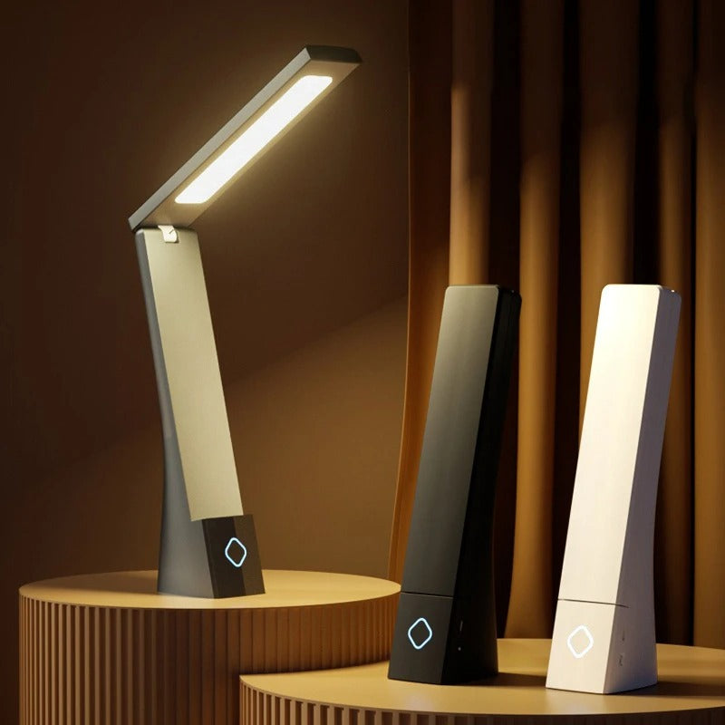 Trois lampes LED modernes noires, blanches et grises posées sur une table